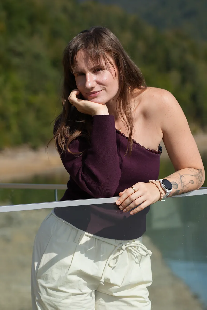 Ilona opiera się o szklaną balustradę nad jeziorem